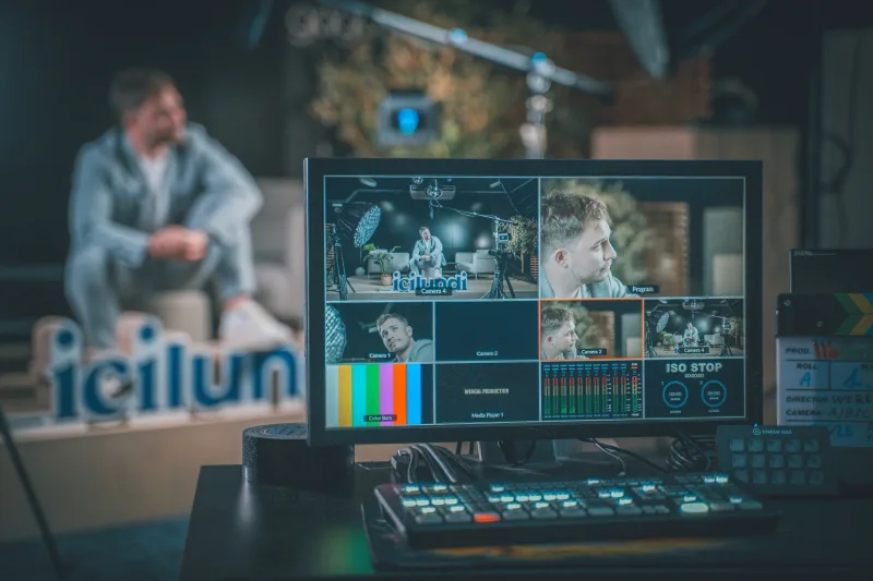 Beeldregie met multiview-monitor en videomixer, waar het programma voor de zaal en de online kijkers samenkomt.